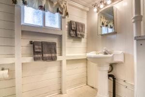 Baño blanco con lavabo y espejo en Timbers Resort en Fairmont Hot Springs