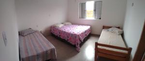 a small bedroom with two beds and a window at POUSADA ALVE VERDe in Capitólio
