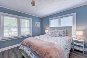 a bedroom with a bed with blue walls and windows at 3BR/2 Bath with King and outside fire Pit in Concord
