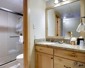 a bathroom with a sink and a toilet and a mirror at Penthouse Ski-In Ski-Out Above Sheraton 1bd 1.5ba in Steamboat Springs +45 photos