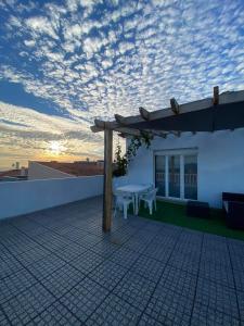 une terrasse avec une table sur le toit d'une maison dans l'établissement Casa Vista Mar, à Castelo do Neiva