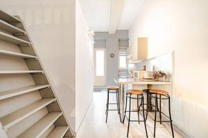 a kitchen with a staircase and bar stools at Quartier Duguesclin & Tête d'Or - Studio - Métro FOCH in Lyon