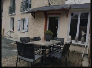 a wooden table with chairs and a potted plant on a patio at Le Syma, en plein centre ville in Le Bourg-dʼOisans