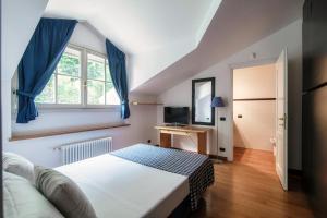 Schlafzimmer mit einem Bett, einem Fenster und einem TV in der Unterkunft I D'A Charming Penthouse - LAKE VIEW in Como