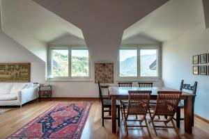 ein Wohnzimmer mit einem Tisch, Stühlen und einem Sofa in der Unterkunft I D'A Charming Penthouse - LAKE VIEW in Como
