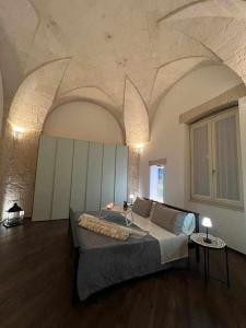 una camera con un grande letto in una stanza con soffitti a volta di Al centro exclusive apartment a Brindisi