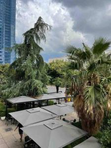 een groep tafels en palmbomen op een patio bij Apartment in Skanderbeg Square - Tirana Center 1 in Tirana