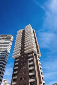 Un palazzo alto di fronte a un cielo blu di Apartamentos Buenos Aires By Mc a Benidorm