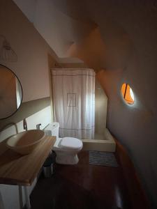 uma casa de banho com um WC branco e um lavatório. em Denmoza Eco Lodge em Potrerillos
