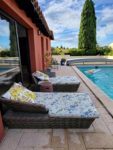 two beds on a patio next to a swimming pool at Maison de Celya in Saint-Georges-dʼOrques