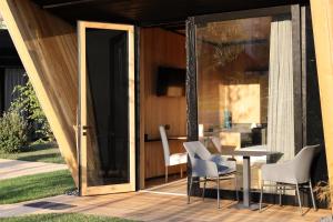 una puerta de cristal que da a un patio con mesa y sillas en Roggia dei Cedri, en Valdobbiadene