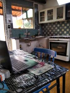 un ordinateur portable assis sur une table dans une cuisine dans l'établissement hostel Lobeira, à Alto Paraíso de Goiás