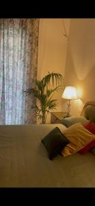 - une chambre avec un lit doté d'une lampe et d'une plante dans l'établissement Appartamento Careggi con posto auto, à Florence