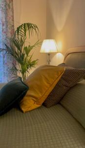 un oreiller sur un lit avec une lampe et une plante dans l'établissement Appartamento Careggi con posto auto, à Florence