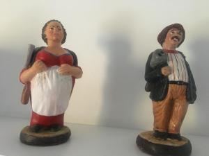 two figurines of a man and a woman on a table at House il Conte in Palermo