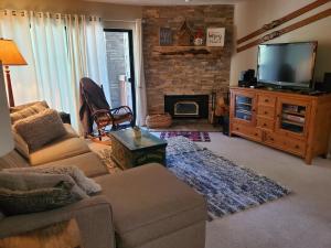 ein Wohnzimmer mit einem Sofa, einem TV und einem Kamin in der Unterkunft Summit Ski Resort 2BR-2BA, Mammoth Lakes in Mammoth Lakes
