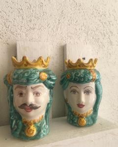 two vases with a statue of a face with a crown at House il Conte in Palermo