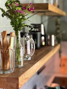 a vase with flowers on a wooden counter top at Viesuliškės Lakeside Glamping in Lakaja