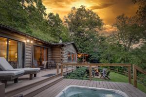 a log cabin with a hot tub on a deck at Magical Mountain Riverfront Retreat near Blue Ridge Georgia with Unforgettable Views! in Mineral Bluff