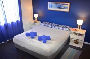 Un dormitorio con una cama con toallas azules. en Mansion Verde en El Calafate