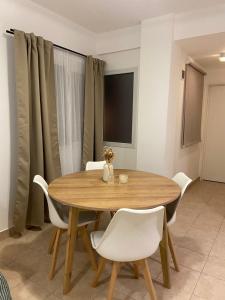 comedor con mesa de madera y sillas blancas en Plaza Caviahue Apartment en Neuquén