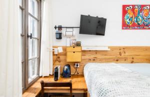 1 dormitorio con 1 cama y TV en la pared en The Cabin at Zwolle Centraal, en Zwolle