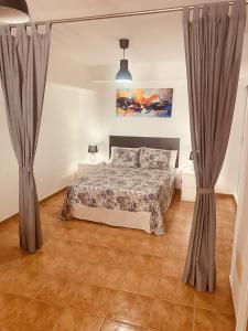 1 dormitorio con 1 cama y 2 cortinas en VV Ancla, en Puerto de Mogán