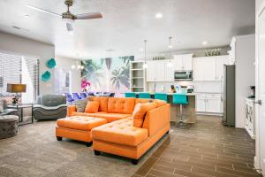 un salon avec un canapé orange et une cuisine dans l'établissement Zion Village Elements 2, Private Backyard Hot Tub, à Hurricane