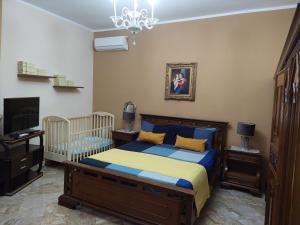 1 dormitorio con cama, cuna y lámpara de araña en Le stanze di Anna, en Capaci