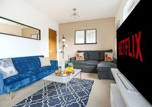 uma sala de estar com um sofá azul e uma mesa em Spacious House - Close to City Centre - Free Parking, Fast Wifi, Smart TVs with Netflix by Yoko Property em Milton Keynes