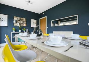 un comedor con una mesa larga y sillas amarillas en Spacious House - Close to City Centre - Free Parking, Fast Wifi, Smart TVs with Netflix by Yoko Property en Milton Keynes