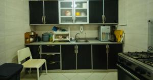uma cozinha com armários pretos e um lavatório em شاليه خاص em Riyadh