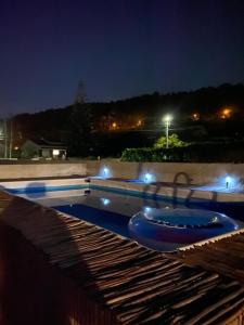 - une piscine avec un bain bleu la nuit dans l'établissement Casa Vista Mar, à Castelo do Neiva