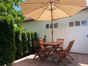 a wooden table with two chairs and an umbrella at SG chaloupka Kubík s wellness v ceně MLÁZOVICE - Český ráj in Mlázovice +39 photos