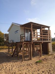 uma casa numa plataforma de madeira na praia em Bahía em Punta Del Diablo