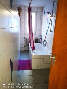 a bathroom with a tub and a red shower curtain at Rosen Garten Haus in Titisee-Neustadt +13 photos