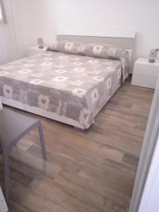 - une chambre avec un lit et du parquet dans l'établissement Casa delle Rose, à Favignana