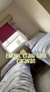 a bedroom with a bed and a window in a room at EMDMC Craig Tara Caravan in Ayr