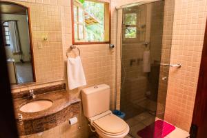 a bathroom with a toilet and a sink and a shower at Pousada Tapera in Penedo