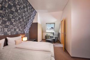 ein Hotelzimmer mit einem Bett und einem Stuhl in der Unterkunft Landhotel Müller in Medebach