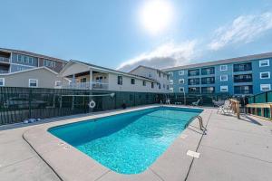 a swimming pool in front of a apartment building at Hang Ten Hideaway, pool, Condo, Parking, payment due upon booking Host will reach out once you book in Carolina Beach