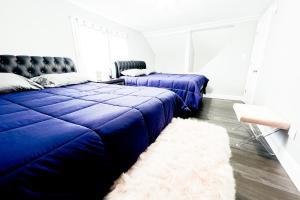 a bedroom with two beds and a white rug at The Ashland Manor in Niagara Falls