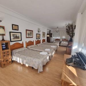 grupa łóżek w pokoju z bronią w obiekcie Finca Rural La Cañera 16 huéspedes w Sewilli