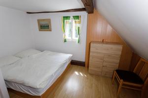 a bedroom with a bed and a dresser and a window at Chata Lomnice U Potoka in Lomnice