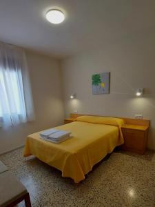 Un dormitorio con una cama amarilla y una ventana en Apartaments Martí, en La Pobla de Segur