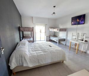 Schlafzimmer mit einem Bett, einem Tisch und einem Fenster in der Unterkunft Vida, hotel de playa in Puerto Madryn