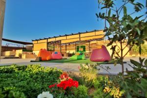 a building with three colorful pots in a garden at Alma Private Villa in Jerash