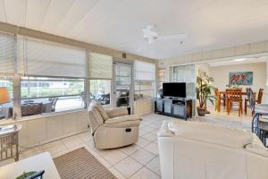 Una sala de estar con muebles blancos y un televisor. en Lakeside House, en Venice