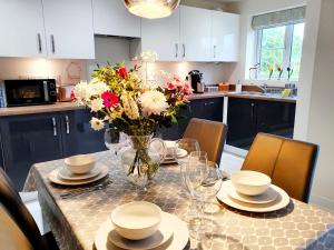 a kitchen with a table with a vase of flowers on it at Meadow View, luxury home in heart of England in Shirebrook