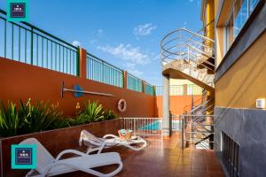 a balcony with a spiral stairway in a building at Tita Apartment Montaña La Data in San Bartolomé